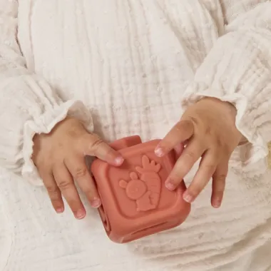 Kūdikis laiko reljefinę minkštą kaladėlę