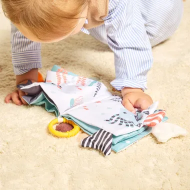 Kūdikis žaidžia su Miniland sensorine knygele Vandenynas.