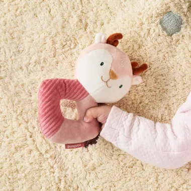 Mergaitė žaidžia su minkštu barškučiu iš Miniland dovanų rinkinio kūdikiams Elniukė